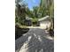 Exterior of home with a brick driveway, garage and lush landscaping with various trees at 4107 Gabriella Ln, Winter Park, FL 32792