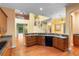 The kitchen area features a large granite countertop, wood cabinetry, and stainless steel appliances, with view to living room at 4107 Gabriella Ln, Winter Park, FL 32792