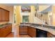The kitchen area features a large granite countertop, wood cabinetry, and stainless steel appliances, with view to living room at 4107 Gabriella Ln, Winter Park, FL 32792
