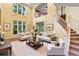 Spacious living room with high ceilings, large windows, and elegant staircase at 4107 Gabriella Ln, Winter Park, FL 32792