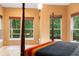 Light-filled main bedroom with windows overlooking backyard foliage at 4107 Gabriella Ln, Winter Park, FL 32792