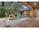 Screened-in pool area features a rock waterfall and brick paving, ideal for outdoor relaxation at 4107 Gabriella Ln, Winter Park, FL 32792