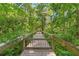 Charming wooded path with a wooden walkway, offering a serene approach to the property at 4107 Gabriella Ln, Winter Park, FL 32792