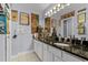 Stylish bathroom featuring a dual sink vanity with dark countertops and decorative posters at 425 Eagle Ridge Dr # 425, Davenport, FL 33837