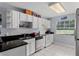 White kitchen featuring granite countertops, white cabinets, stainless sink and appliances, and a window with a view at 425 Eagle Ridge Dr # 425, Davenport, FL 33837