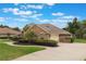 Side view of a brick home showing the garage and driveway, surrounded by a manicured lawn at 441 Hightower Dr, Debary, FL 32713