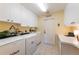 Laundry room with white washer and dryer, overhead cabinets for storage, sink, and a folding desk at 441 Hightower Dr, Debary, FL 32713