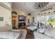 Inviting living room with comfortable seating, view into sun room, dark hard wood floors and a decorative ceiling fan at 441 Hightower Dr, Debary, FL 32713