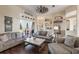 Bright open-concept living room with comfortable seating, view into sun room, dark hard wood floors and lots of light at 441 Hightower Dr, Debary, FL 32713