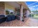 Covered patio with grill, comfortable seating, and brick detailing overlooking the backyard at 441 Hightower Dr, Debary, FL 32713