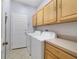 The laundry room includes front-loading washer and dryer, cabinet storage, and tile flooring at 4558 Redmond Pl, Sanford, FL 32771