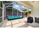 Screened patio with comfortable blue wicker seating and a ceiling fan for relaxing outdoors at 4558 Redmond Pl, Sanford, FL 32771