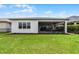 Lush green backyard with a screened lanai and views of the home's exterior at 5013 E Fountainwood Dr, St Cloud, FL 34772