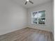 Neutral bedroom boasts wood-look floors, white walls, and a large window providing natural light at 5013 E Fountainwood Dr, St Cloud, FL 34772