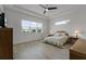 A bright bedroom features a tray ceiling, wood-look flooring, and large windows with neighborhood views at 5013 E Fountainwood Dr, St Cloud, FL 34772