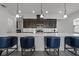 A modern kitchen featuring dark wood cabinets, white subway tile, and a large marble island with seating at 5013 E Fountainwood Dr, St Cloud, FL 34772