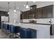Modern kitchen showcases a large marble island with seating, dark cabinets, and stainless steel appliances at 5013 E Fountainwood Dr, St Cloud, FL 34772