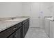 Functional laundry room features dark cabinetry and granite countertop space at 5013 E Fountainwood Dr, St Cloud, FL 34772