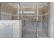 Tiled shower includes glass doors, a built-in seat, and stainless steel grab bars for accessibility at 5013 E Fountainwood Dr, St Cloud, FL 34772