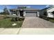 Charming single-Gathering home features a gray exterior, a two-car garage and a brick paver driveway at 5262 Teirgarten St, St Cloud, FL 34771