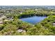 Beautiful aerial view of the lake, surrounding trees, and a home at 5655 Oak Hollow Ln, Oviedo, FL 32765