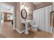 A bathroom featuring a pedestal sink, oval mirror, and a shower with a curtain at 5655 Oak Hollow Ln, Oviedo, FL 32765