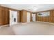 Spacious bedroom featuring wood paneling, neutral carpet, a ceiling fan, and a bright window at 5655 Oak Hollow Ln, Oviedo, FL 32765