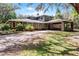 Charming home featuring mature landscaping, stone accents, and a covered portico at 5655 Oak Hollow Ln, Oviedo, FL 32765
