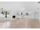 Bright kitchen and living room with white cabinets, stainless appliances, and brick fireplace at 5655 Oak Hollow Ln, Oviedo, FL 32765