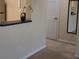 Hallway with neutral carpet leads past a closet and partial kitchen view with a breakfast bar at 581 Brantley Terrace Way # 302, Altamonte Springs, FL 32714