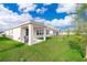 Spacious backyard featuring a covered patio, lush green lawn and play set at 6984 Dilly Lake Ave, Groveland, FL 34736