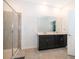 Contemporary bathroom with a double vanity, dark cabinets, a large mirror, and a glass-enclosed tiled shower at 6984 Dilly Lake Ave, Groveland, FL 34736