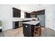 Stylish kitchen with stainless steel appliances, a center island with bar stools, and sleek dark cabinetry at 6984 Dilly Lake Ave, Groveland, FL 34736