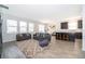 Open living room with modern furnishings, a neutral rug, and seamless connection to the kitchen at 6984 Dilly Lake Ave, Groveland, FL 34736