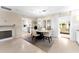 The dining room displays a glass dining table, contemporary chandelier, and decor with a view to the kitchen and living room at 701 Lakeshore Blvd, St Cloud, FL 34769