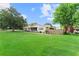 Well-maintained home featuring a large, green front lawn, screened porch, and mature landscaping at 701 Lakeshore Blvd, St Cloud, FL 34769