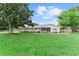 Landscaped single-story home with a lush lawn, mature trees, and a quaint screened front porch at 701 Lakeshore Blvd, St Cloud, FL 34769