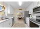 Bright kitchen with white cabinetry, modern appliances, and an open layout seamlessly connecting to the dining area at 701 Lakeshore Blvd, St Cloud, FL 34769