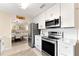 Bright kitchen features stainless steel appliances, white cabinetry, and an adjacent dining area at 701 Lakeshore Blvd, St Cloud, FL 34769