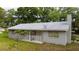 An exterior side view of a single-story home with a chimney and small porch at 715 Ballard St, Altamonte Springs, FL 32701