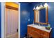 Bathroom featuring blue walls, vanity with granite countertop, and framed mirror at 718 Wildwood Dr, Winter Springs, FL 32708