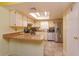 Well-lit kitchen features white cabinets, updated appliances, and a breakfast bar overlooking the dining area at 718 Wildwood Dr, Winter Springs, FL 32708