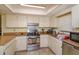Functional kitchen featuring white cabinets, updated appliances, and tile backsplash at 718 Wildwood Dr, Winter Springs, FL 32708