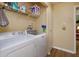 Well-equipped laundry room with modern washer, dryer, shelves, and ample storage space at 718 Wildwood Dr, Winter Springs, FL 32708