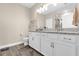 Bright bathroom showcasing a double vanity with white cabinetry and modern fixtures at 7573 Laureate Blvd # 1-404, Orlando, FL 32827
