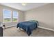 Bedroom with natural light, plush carpet, and cozy blue comforter at 7573 Laureate Blvd # 1-404, Orlando, FL 32827