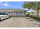 Attached garage with paved driveway, assigned parking spot, and well manicured landscape at 7573 Laureate Blvd # 1-404, Orlando, FL 32827