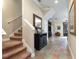 Entryway with tile flooring, staircase, elegant console table, and open access to the living spaces at 804 Challis Pt, Longwood, FL 32779