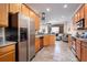 Open-concept kitchen with stainless steel appliances, wood cabinets, and tile flooring overlooking the living room at 804 Challis Pt, Longwood, FL 32779