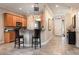 Well-lit kitchen with wood cabinets, bar seating, tile floors, and an open layout to the entryway at 804 Challis Pt, Longwood, FL 32779